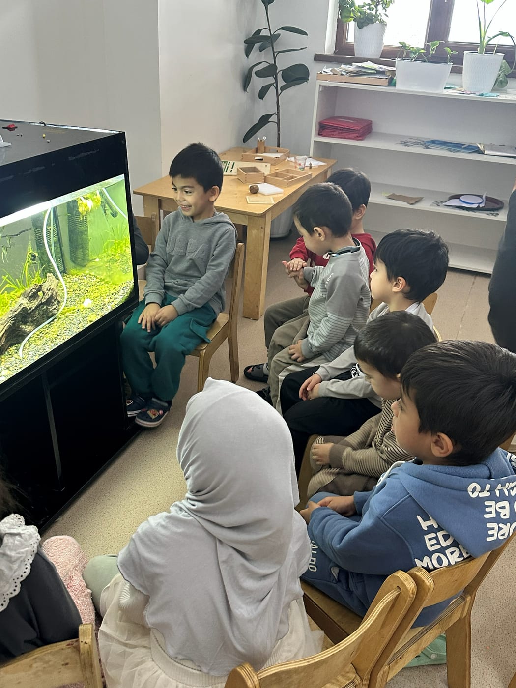 Sinfdagi akvarium atrofiga to'plangan bolalar